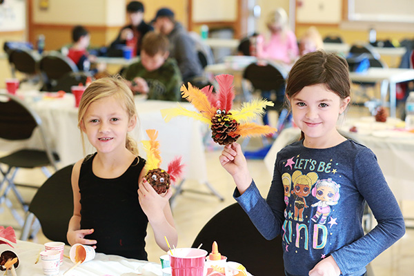 Two young girls showing off artwork